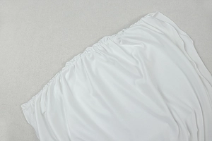 Vue détaillée de la texture froncée élastique et du tissu plissé blanc d'un ensemble