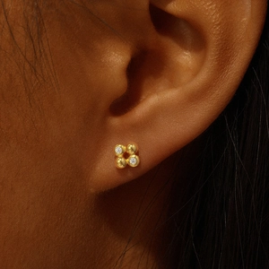 Close-up of a s925 silver gold-plated cartilage stud with cubic zirconia in four-ball design