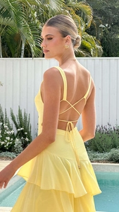 Detail of cross tie back and tiered ruffles on a vibrant yellow summer backless dress