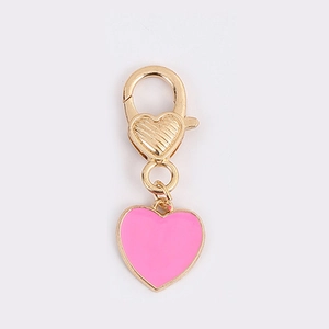 Close-up of pink heart charm pendant with golden lobster clasp for keychains and bags