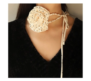 Close-up of beige polka dot chiffon rose flower choker necklace on female model neck