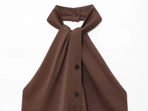 Close-up of brown halter neck top with tie-knot neckline and front button details