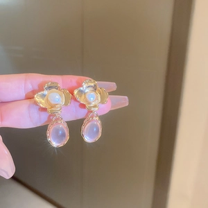 Detail of vintage flower earrings featuring white pearls and pink oval resin stones