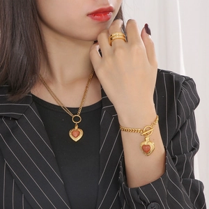 Détails de l'ensemble collier et bracelet doré avec pierres opales rouges en cœur