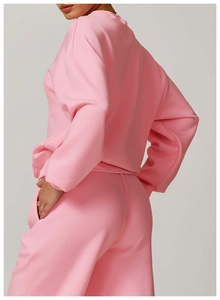 Détail d'un ensemble de sport rose avec sweat à col rond et pantalon en coton doux