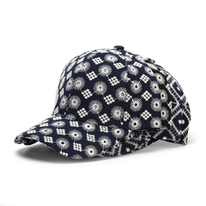 Vista detallada de gorra de béisbol azul oscuro con bordados florales blancos finos