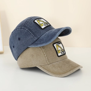 Close-up of kids' denim baseball caps featuring detailed excavator embroidery and washed fabric