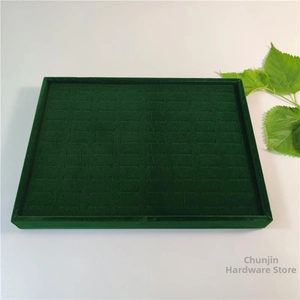 Close-up of deep green velvet jewelry tray with slots for ring and earring storage