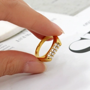Close-up of hand holding 18K gold plated ring with rectangular zircon inlay detail