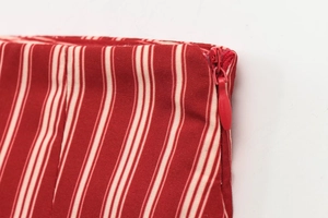 Detail of red and cream striped midi dress featuring a hidden zipper and fine stitching