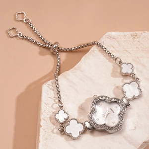 Macro shot of clover-shaped watch dial with crystals on stone base with pull-chain band
