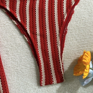 Détail de maillot de bain crocheté à rayures rouges et crème avec texture bohème