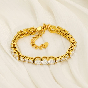 Close-up of 18K gold-plated tennis bracelet with round cubic zirconia on white silk