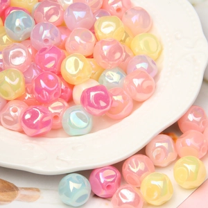 Close-up of colorful iridescent acrylic beads in a white relief plate for DIY crafting