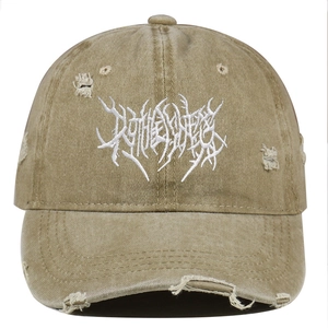 Close-up of khaki washed canvas baseball cap with heavy metal embroidery and distressed details