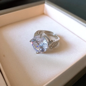 Macro shot of oval cubic zirconia ring with micro-pave details on a velvet jewelry box