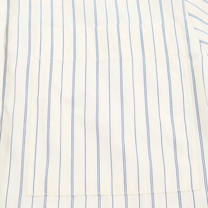 Detail view of cotton striped shirt featuring a blue vertical pattern and chest pocket