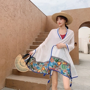 White bohemian linen shawl with blue embroidery and tassels for beach sun protection