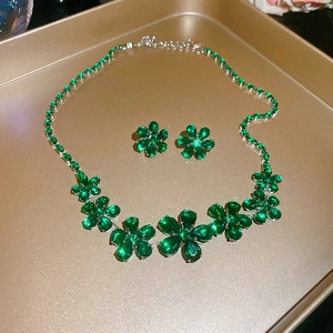 Detailed macro view of green zircon flower pendant necklace and matching floral earrings