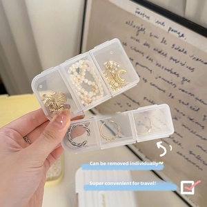 Détail d'une boîte à bijoux transparente avec trois compartiments pour bagues et colliers