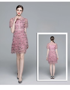 Détail de robe florale rose avec col perlé et jupe en tulle à plusieurs couches