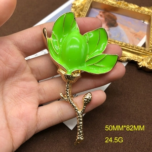 Macro shot of green enamel magnolia brooch with dimensions 50MM x 82MM and 24.5G weight