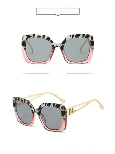 Details einer quadratischen Vintage-Sonnenbrille mit hohlen Metallbügeln und grauen Gläsern
