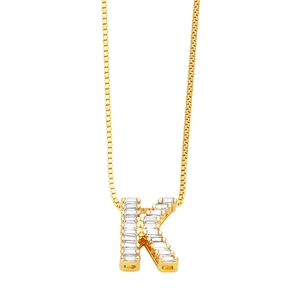 Detailed view of a gold-plated letter K pendant set with sparkling cubic zirconia stones
