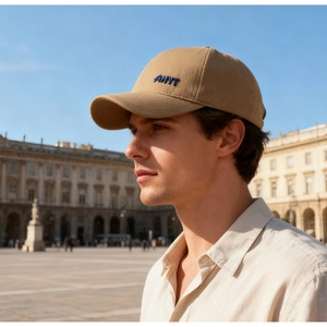 Detailed close-up of khaki baseball cap with blue embroidered letter AHYT on high-quality fabric