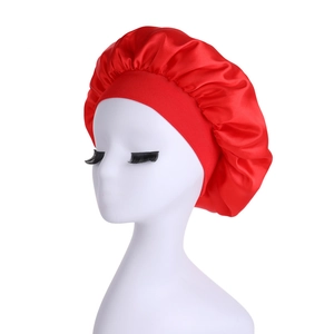 Detail of red satin sleep cap featuring wide elastic band and pleated glossy silk texture