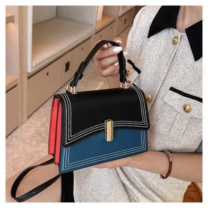 Détail du sac à main en cuir tricolore avec surpiqûres blanches et fermoir doré