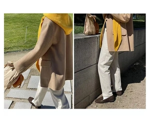 Detail of beige wool texture cardigan paired with yellow hoodie and white casual trousers