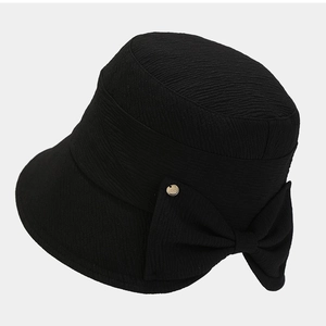 Black foldable sun hat for women featuring a large bow and gold buckle on woven fabric