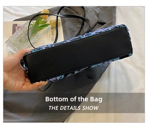 Detailed base view of purple sequin shell tote bag with black leather bottom and stitching
