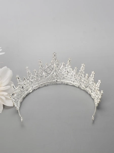 Detailed close-up of a silver princess crown tiara on a minimalist grey background