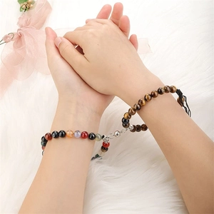 Magnetic chakra tiger eye beaded bracelets for couples on a white plush background