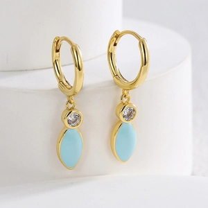 Elegant gold earrings with light blue enamel leaf and brilliant zircon drop on white stand