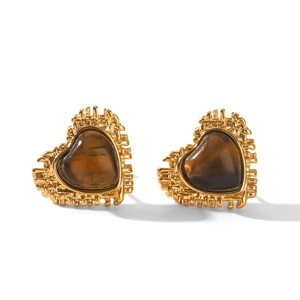 Macro detail of heart-shaped gold earrings with tiger eye stone and vintage texture