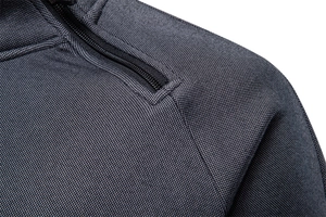 Macro shot of dark grey fleece hoodie showing zipper detail and high-quality fabric texture