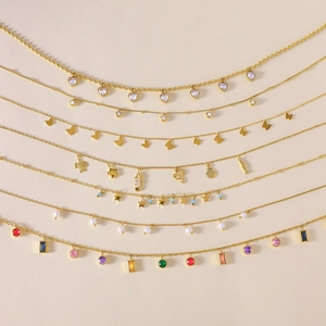 Detail of seven gold titanium necklaces featuring zircon hearts, stars and sea life charms