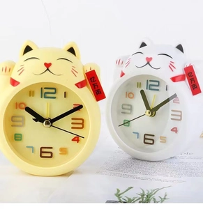 Detailed view of yellow and white Maneki Neko lucky cat clocks with lucky coin tags