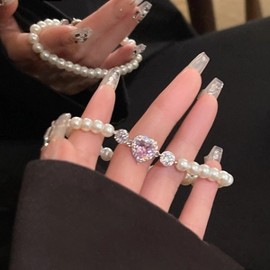 Détail du bracelet en perles avec breloque cœur en zircon rose et accents brillants