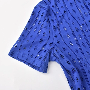 Detail view of Klein blue hollow-out knit fabric with circular cutouts on the sleeve