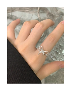 Detailed view of an irregular bow knot ring in S925 sterling silver worn on hand