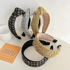 Detailed view of knotted braided headbands in metallic gold, silver and black colors
