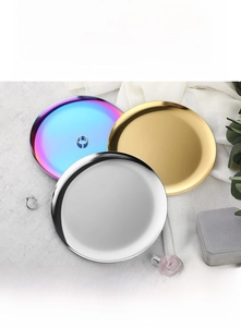 Close-up of sleek stainless steel round trays in gold, silver and iridescent finishes