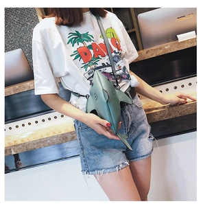 Green shark shaped crossbody bag shown on model highlighting creative animal style