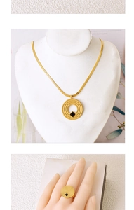 Detail of gold circular necklace and ring set with square black gemstone inlays