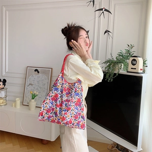 Floral canvas tote bag with drawstring detail worn by a model in a cozy French style setting
