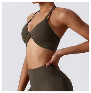 Detail of dark olive green sports bra with twist front and high-waisted yoga leggings